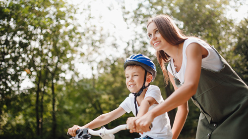 mother and son enjoying a bike ride in nature wearing helmets healthy outdoor fun family activity