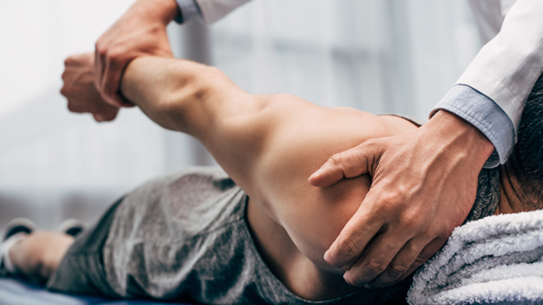 person receiving shoulder therapy from therapist showing physical recovery techniques